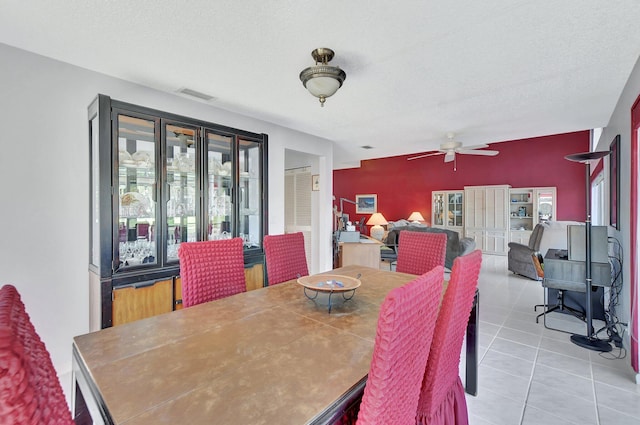 dining area featuring light tile patterned floors, a textured ceiling, and ceiling fan