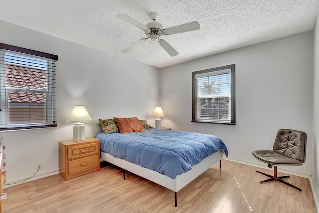 bedroom featuring ceiling fan, a textured ceiling, and light hardwood / wood-style flooring