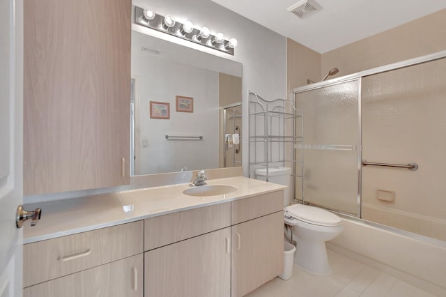 full bathroom featuring tile patterned floors, vanity, bath / shower combo with glass door, and toilet