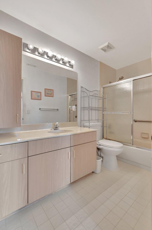 full bathroom with combined bath / shower with glass door, vanity, toilet, and tile patterned flooring