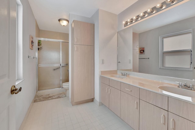 bathroom featuring tile patterned flooring, vanity, toilet, and walk in shower