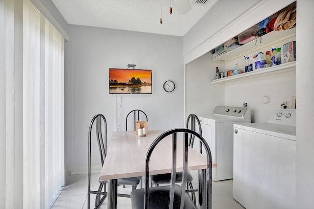 clothes washing area with washer and clothes dryer and a textured ceiling