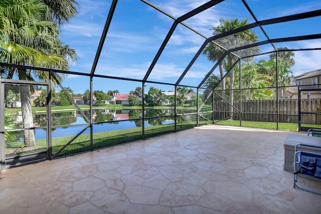 view of patio / terrace featuring a lanai and a water view