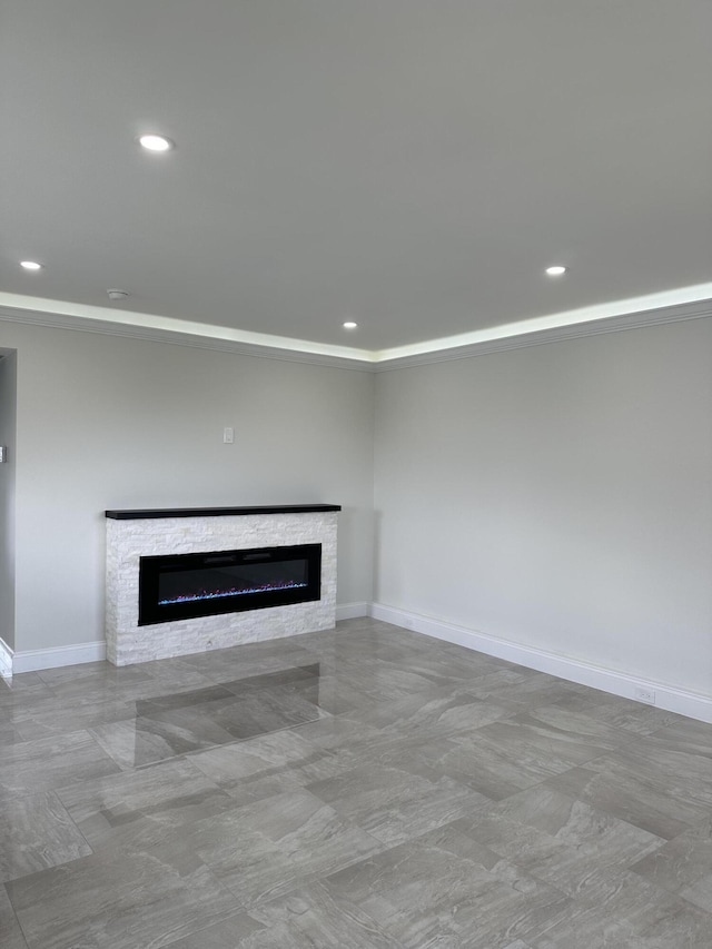 unfurnished living room featuring a stone fireplace, recessed lighting, and baseboards