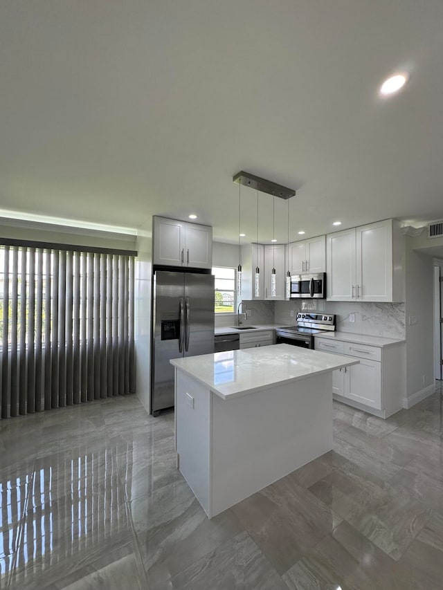 kitchen with white cabinets, light tile patterned flooring, stainless steel appliances, and decorative light fixtures