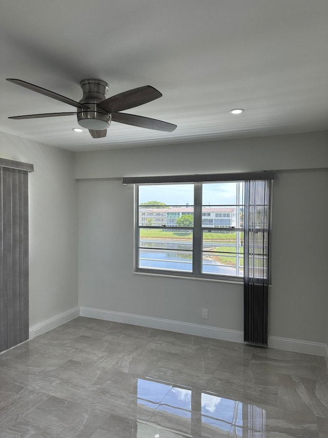 unfurnished room with light tile patterned flooring and ceiling fan