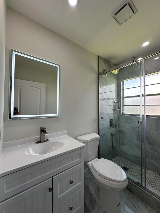 bathroom featuring toilet, tile patterned floors, vanity, and an enclosed shower