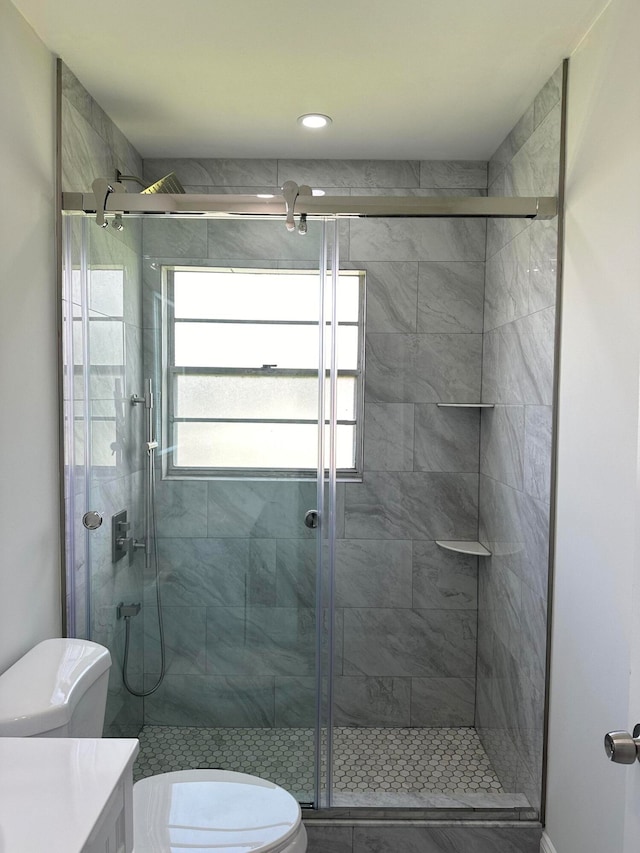 bathroom with walk in shower, toilet, plenty of natural light, and vanity