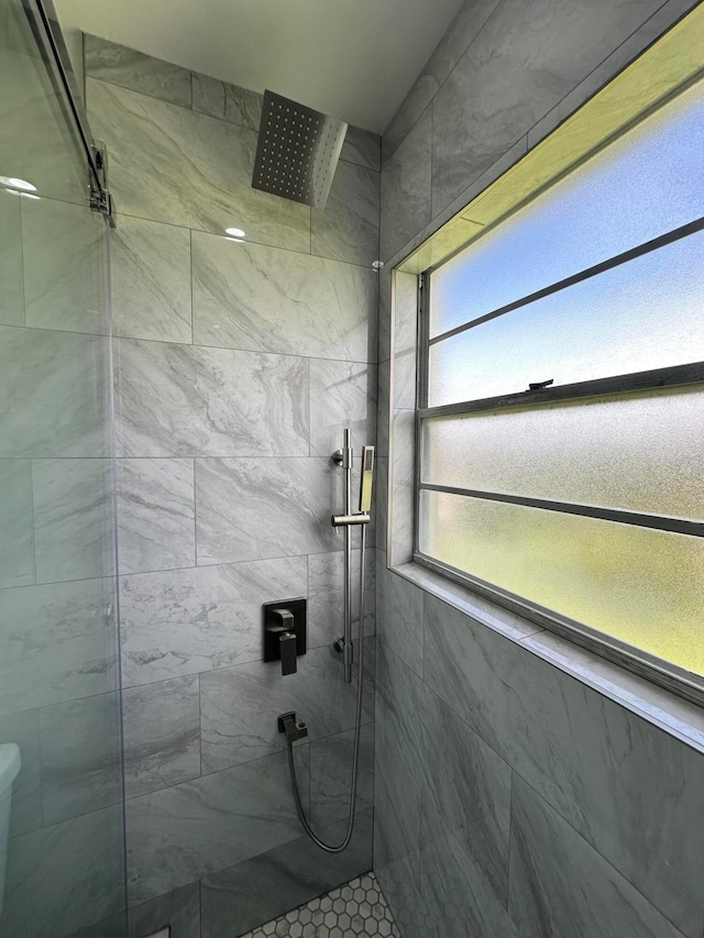 bathroom with tiled shower and toilet