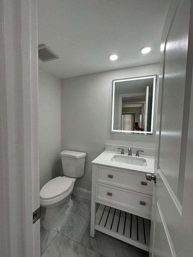 bathroom featuring tile patterned floors, vanity, and toilet