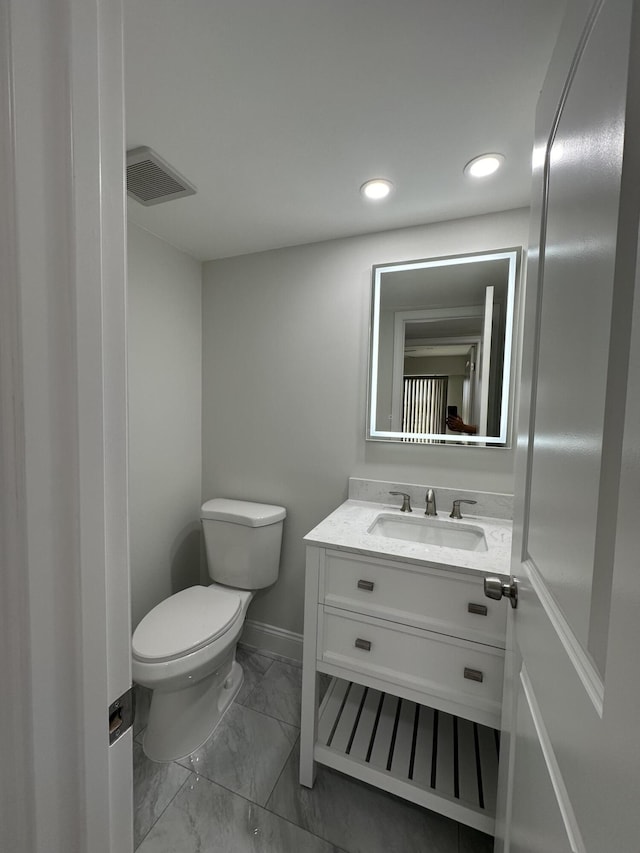 bathroom featuring toilet, vanity, visible vents, baseboards, and marble finish floor