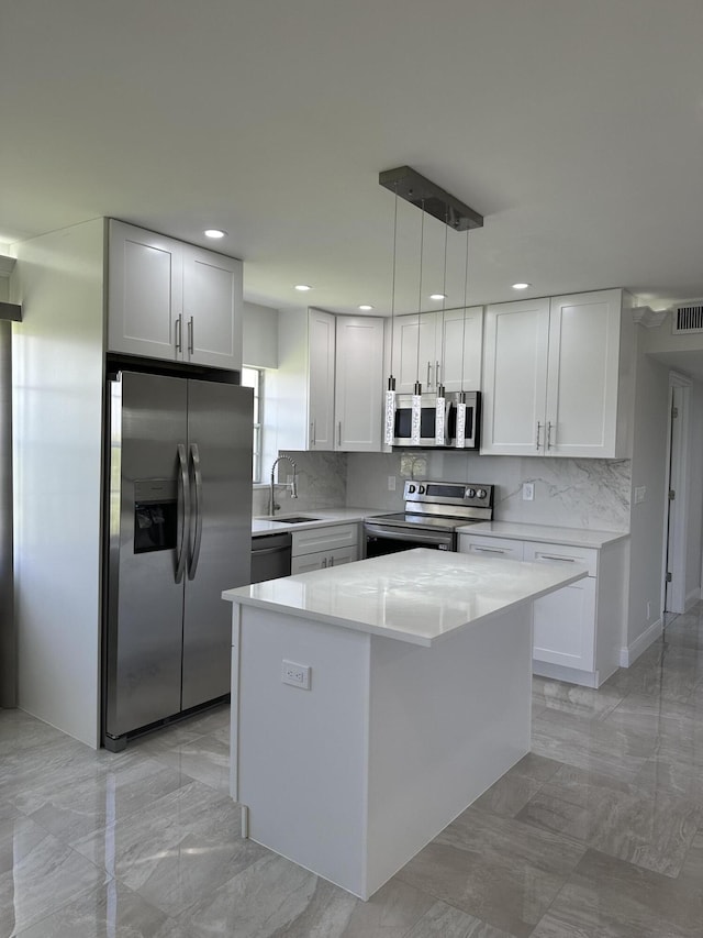 kitchen with stainless steel appliances, pendant lighting, and white cabinets