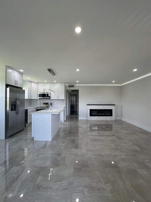 kitchen with white cabinets, pendant lighting, tile patterned floors, backsplash, and stainless steel appliances