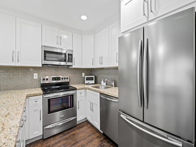 kitchen featuring tasteful backsplash, stainless steel appliances, dark hardwood / wood-style flooring, and white cabinetry