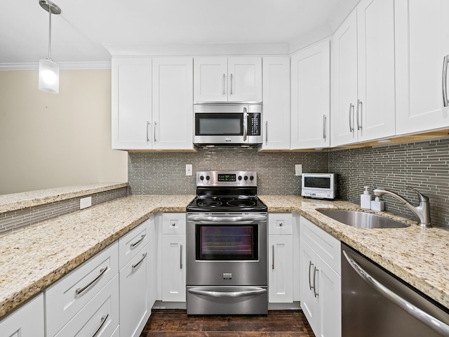 kitchen with appliances with stainless steel finishes, backsplash, ornamental molding, white cabinets, and dark hardwood / wood-style floors