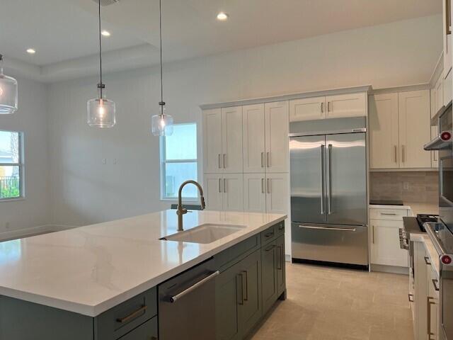 kitchen with sink, an island with sink, stainless steel appliances, and plenty of natural light