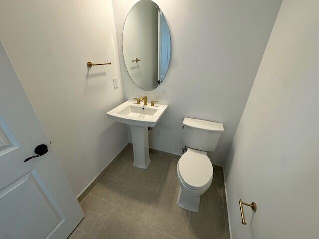 bathroom with toilet and tile patterned floors