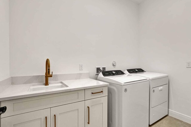 clothes washing area with washer / dryer, sink, and cabinets