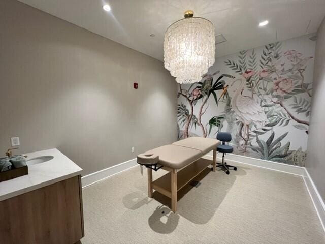 carpeted office space featuring a notable chandelier and sink