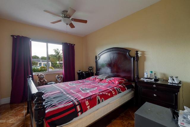 bedroom with ceiling fan and dark parquet floors