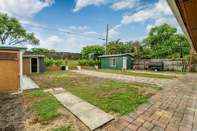 view of yard featuring a storage unit and a patio