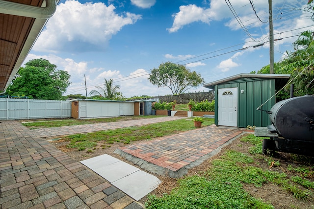 view of yard featuring a storage shed and a patio area