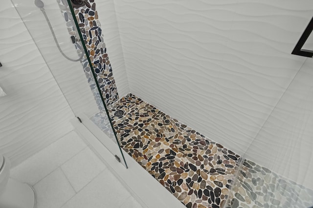 room details with a shower, tile patterned flooring, and toilet