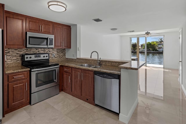 kitchen featuring sink, light tile patterned floors, a water view, and stainless steel appliances