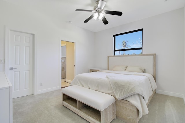 bedroom with ceiling fan, ensuite bathroom, and light colored carpet