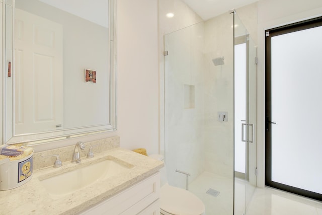 bathroom featuring vanity, toilet, and a shower with shower door