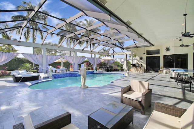 view of pool with pool water feature, glass enclosure, ceiling fan, and a patio