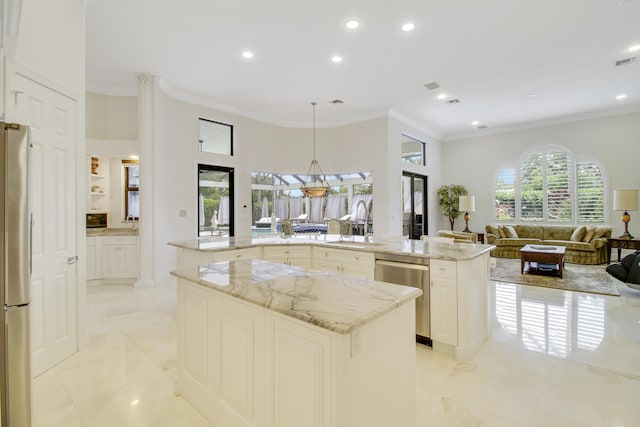 kitchen featuring ornamental molding, an island with sink, appliances with stainless steel finishes, decorative light fixtures, and light stone counters