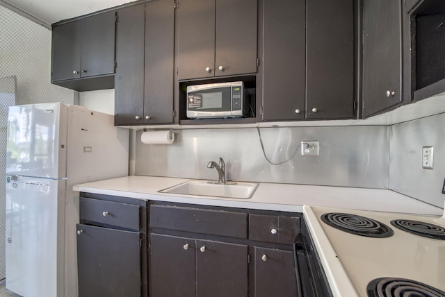 901 N Birch Rd Unit D6, Fort Lauderdale, FL 33304 - kitchen featuring stainless steel microwave, range with electric stovetop, a sink, freestanding refrigerator, and light countertops
