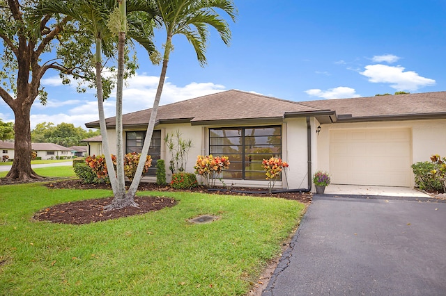 single story home with a garage and a front lawn