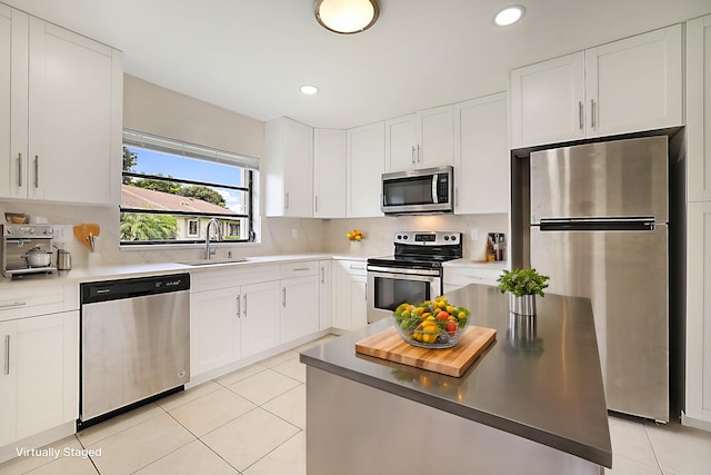 kitchen featuring appliances with stainless steel finishes, sink, and white cabinets