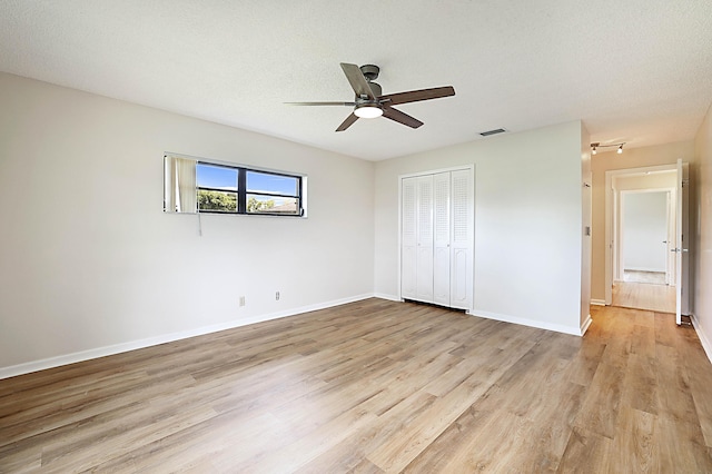 unfurnished bedroom with ceiling fan, light hardwood / wood-style floors, a closet, and a textured ceiling