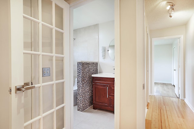 bathroom with tile patterned floors, vanity, toilet, and a textured ceiling