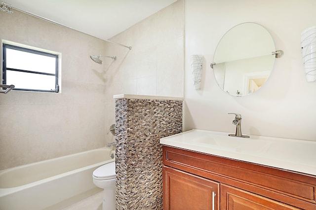 full bathroom with tiled shower / bath, vanity, and toilet