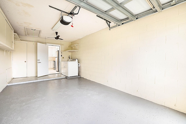 garage with a garage door opener, stainless steel fridge, and separate washer and dryer