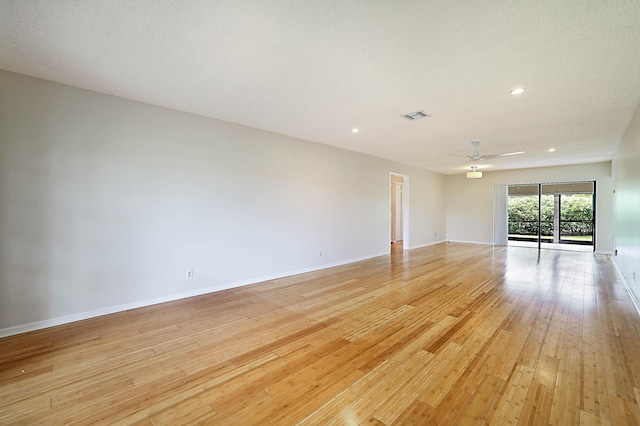 unfurnished room featuring a textured ceiling, ceiling fan, and light wood-type flooring