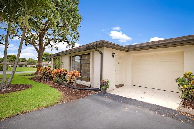 view of front of home featuring a garage and a front lawn