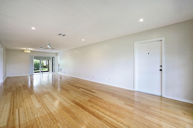 unfurnished room featuring light hardwood / wood-style flooring and a textured ceiling