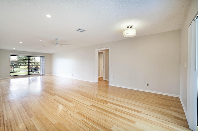 unfurnished room featuring a textured ceiling, ceiling fan, and light hardwood / wood-style flooring