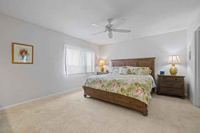 bedroom featuring light colored carpet, a textured ceiling, and ceiling fan