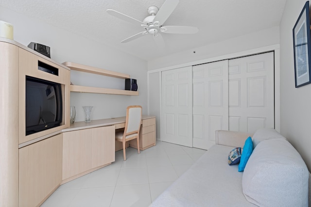 tiled bedroom with ceiling fan and a closet