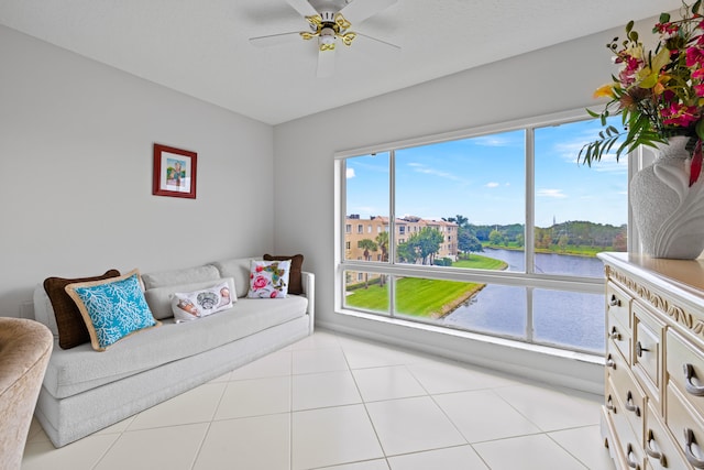 living room featuring a wealth of natural light, light tile patterned flooring, and a water view