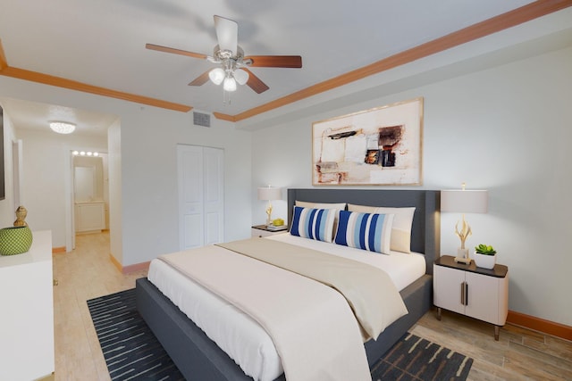 bedroom featuring ceiling fan, ornamental molding, a closet, and light hardwood / wood-style flooring