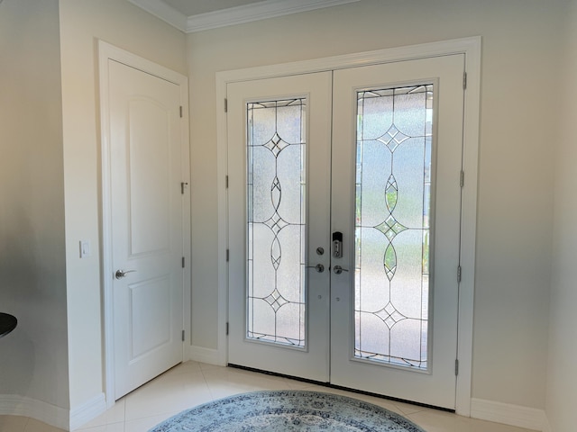 tiled foyer with crown molding and french doors