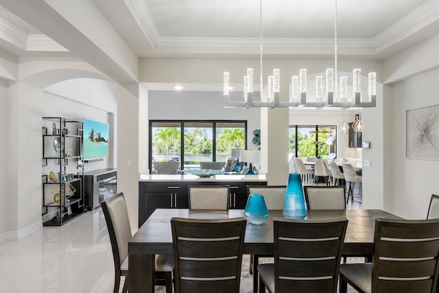 dining area featuring ornamental molding and light tile patterned flooring