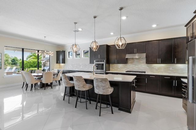 kitchen featuring a center island with sink, hanging light fixtures, crown molding, and stainless steel gas stovetop